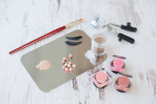 Rôzne make-upy a kozmetické produkty, púder, lícenka a trblietavý flitr na palete make-upu.