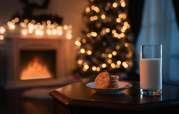 Acogedor cuarto de Nadal pola noite con vaso de leite e galletas preparadas para o Papá Noel