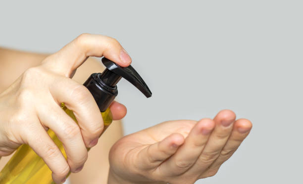 hand holding dispenser anti cellulite oil pressing to pour in another hand. concept of beauty home spa with massage, oil, body anti-cellulite, body care. skin  cosmetic product mockup, free space for text