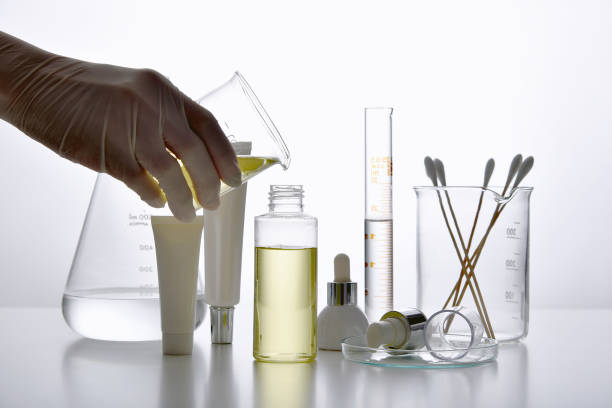 Dermatologist formulating and mixing pharmaceutical skincare, Cosmetic bottle containers and scientific glassware, Research and develop beauty product concept.