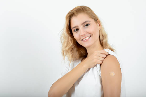 Young woman showing arm after vaccine injection