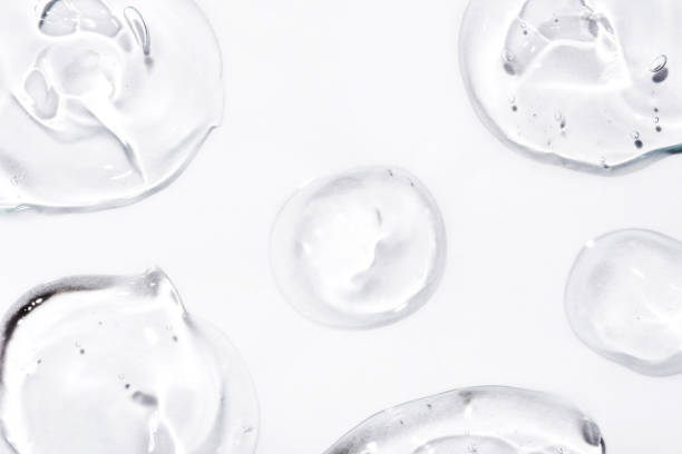 Transparent hyaluronic acid gel drops on a white background.